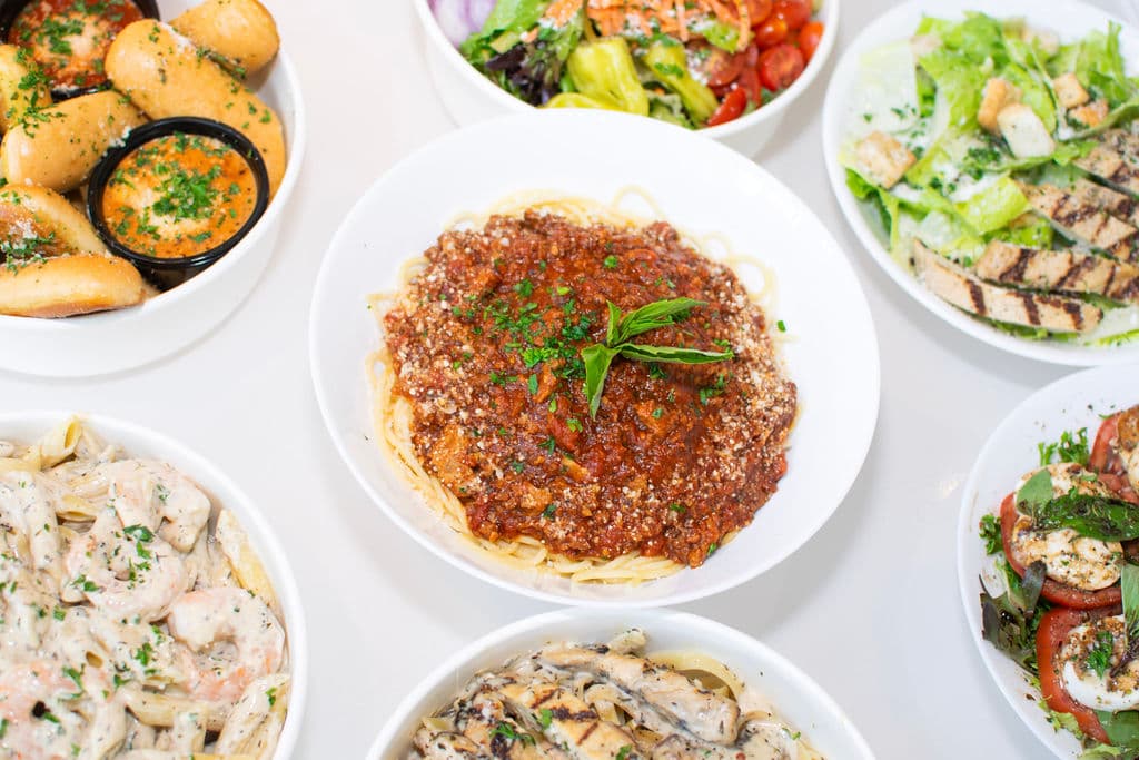 A spread of Pastella pasta dishes, salads, and garlic bread